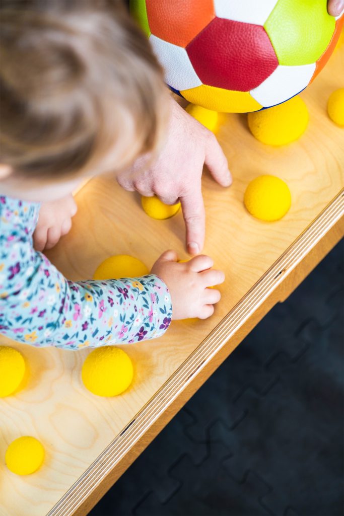 Im Motorikraum wird mit Bällen und Matten hantiert, gebaut und gespielt
